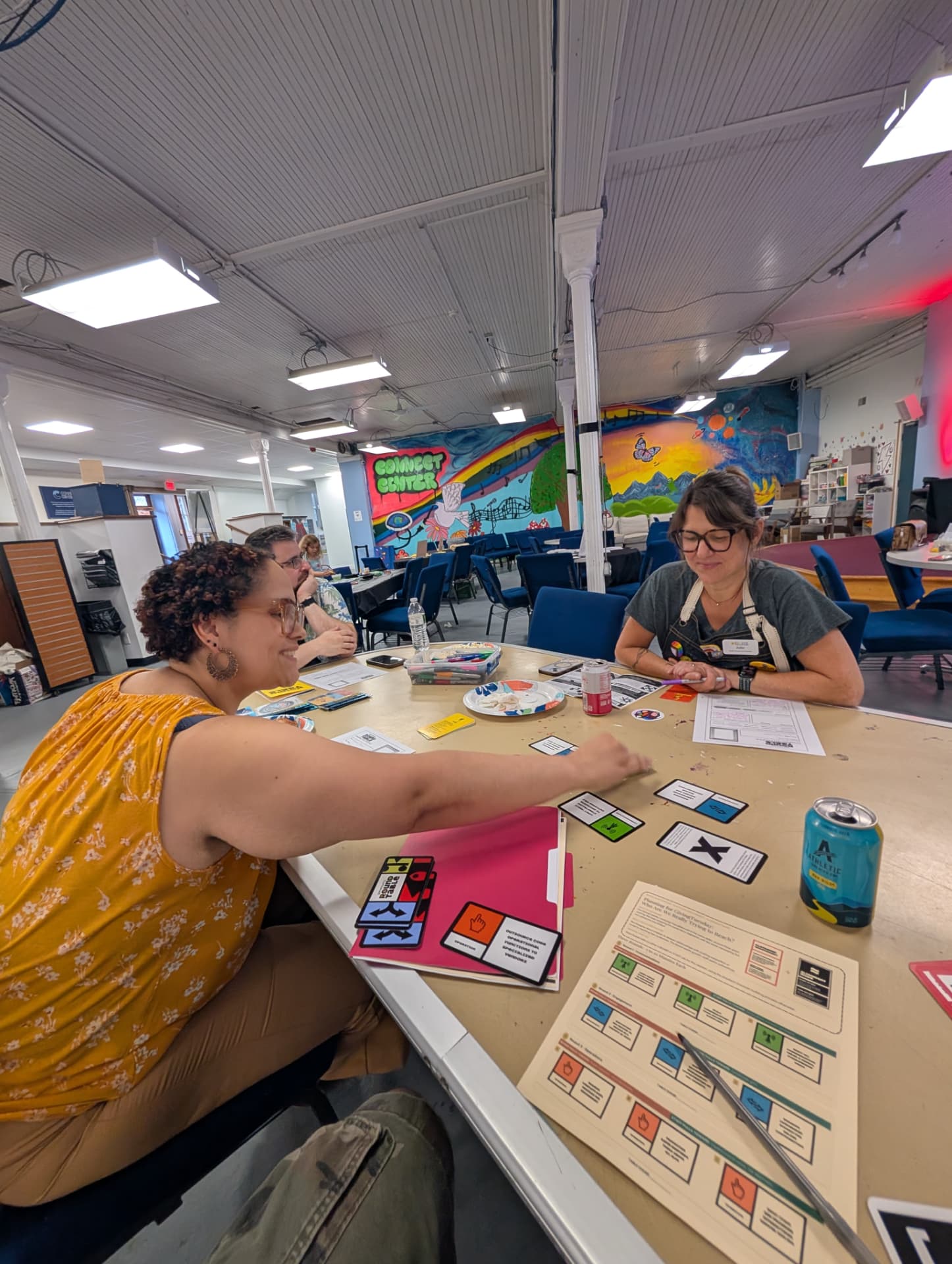 Two players laying down cards at a community center table.