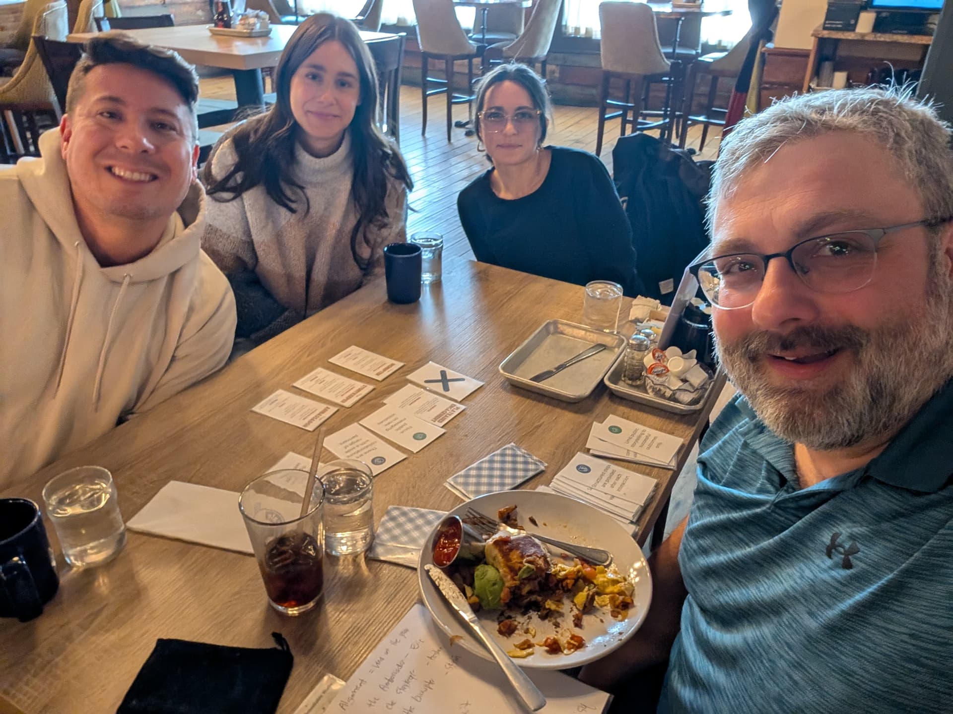 Four players smiling around a cafe table mid-session.